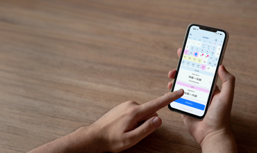 Anställd använder mobilapp med kalendervy för att registrera arbetstid – smidig och effektiv tidrapportering för lön och planering.