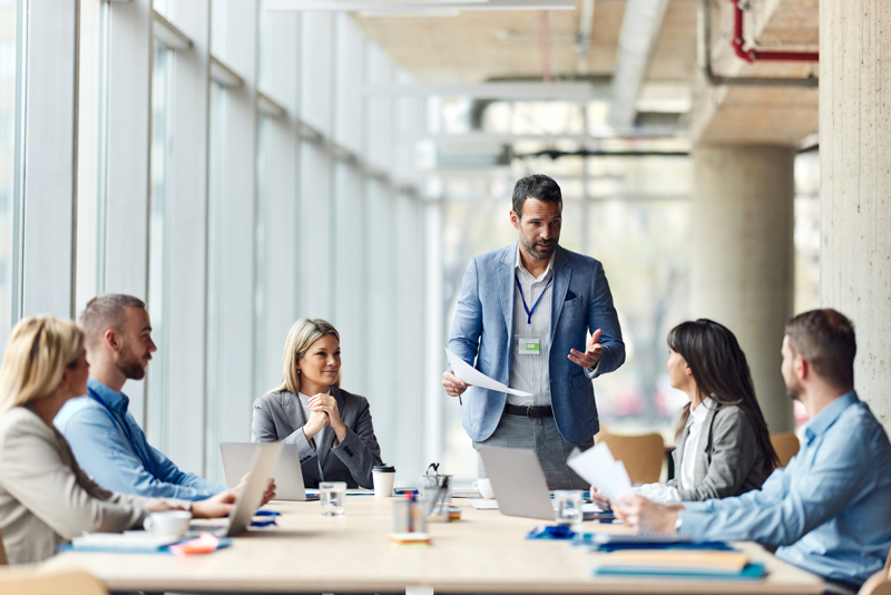 Chef håller möte med sitt team om implementering av AI-baserad workforce management för bättre schemaläggning, tidrapportering och optimering av arbetsstyrkan.