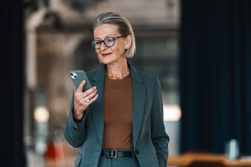 Chef kontrollerar schema och tidrapportering på sin smartphone via en AI-driven workforce management-lösning som ger överblick över medarbetare och planering.