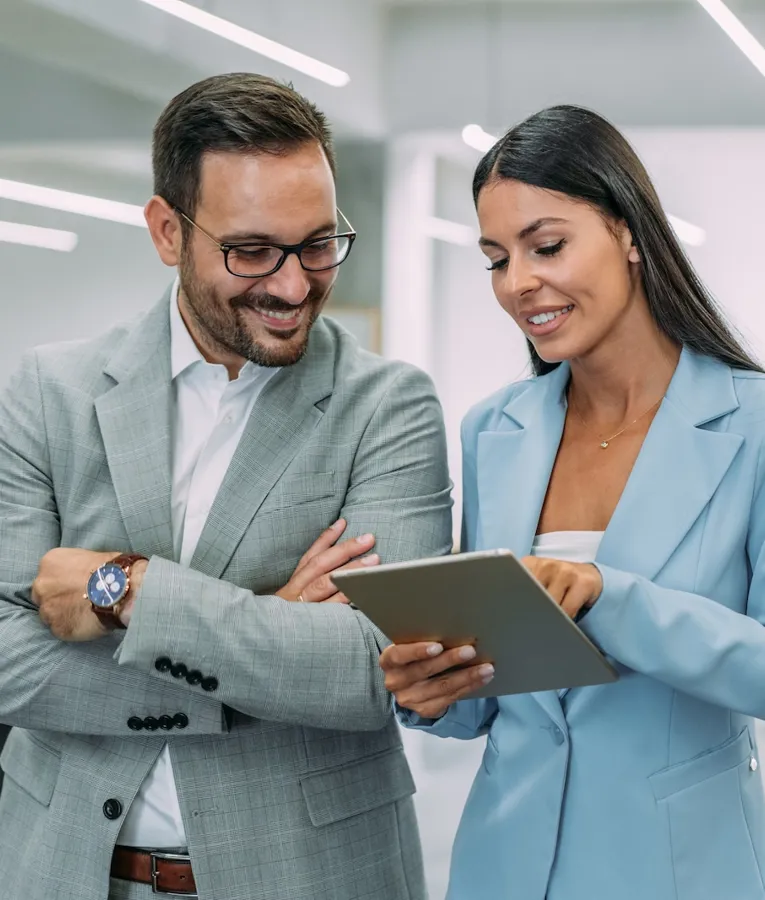 Två yrkespersoner granskar personaldata på surfplatta och visar samarbete kring digital schemaläggning och mobil planering.