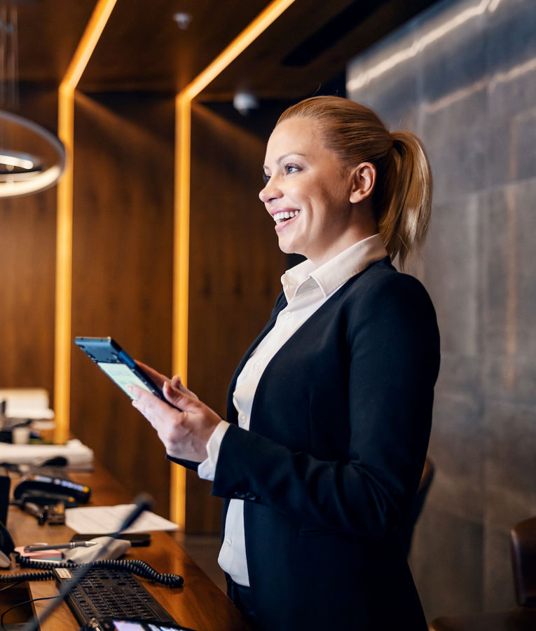 En vänlig receptionist hälsar gäster välkomna och hanterar incheckningar.