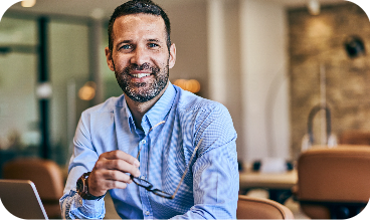 Chef ler vid skrivbord med skärm – tillgång till realtidsdata för tidrapportering, bemanning och personalöversikt.