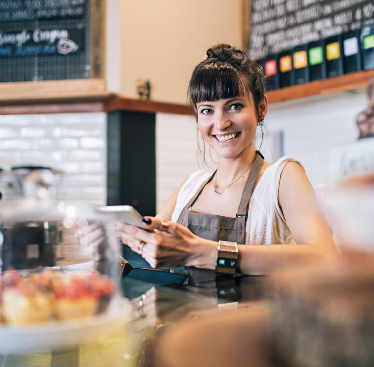 En glad caféanställd serverar kaffe och bakverk för att förbättra kundupplevelsen.